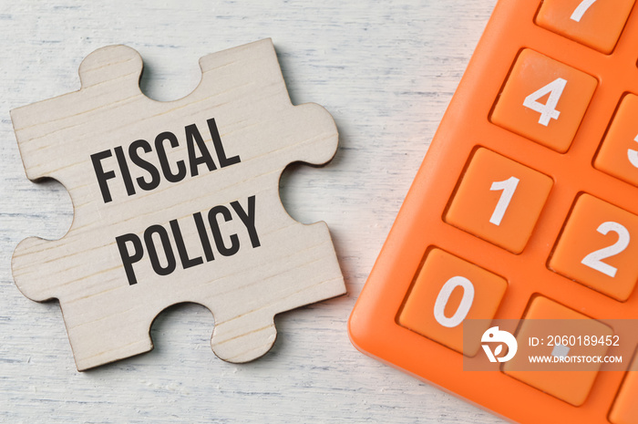 Calculator and wooden puzzle with text FISCAL POLICY