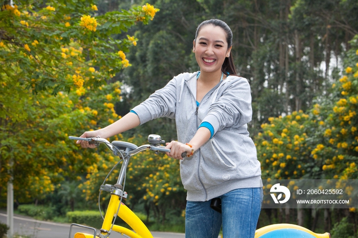 一个年轻女大学生在校园里骑车