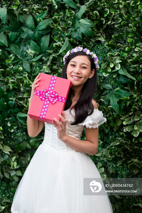 带花环的年轻女人抱着礼物盒