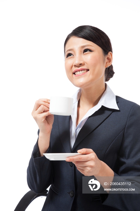 棚拍年轻商务女士坐在办公椅上喝咖啡