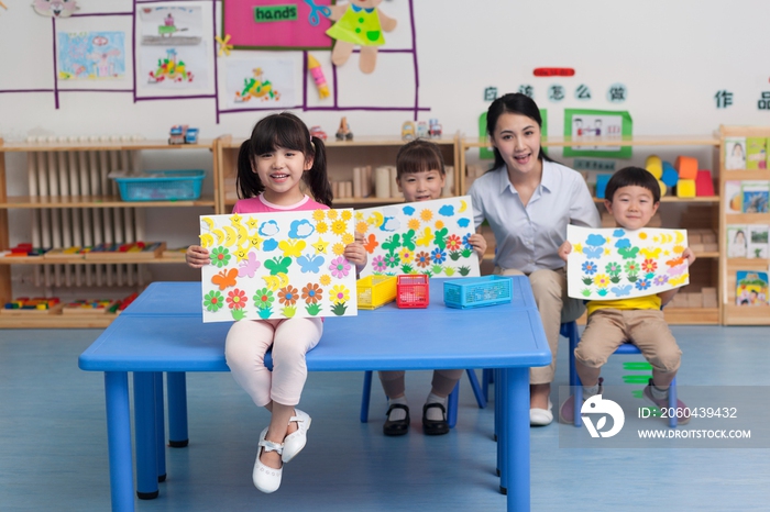 幼儿园女老师和儿童展示手工儿童画