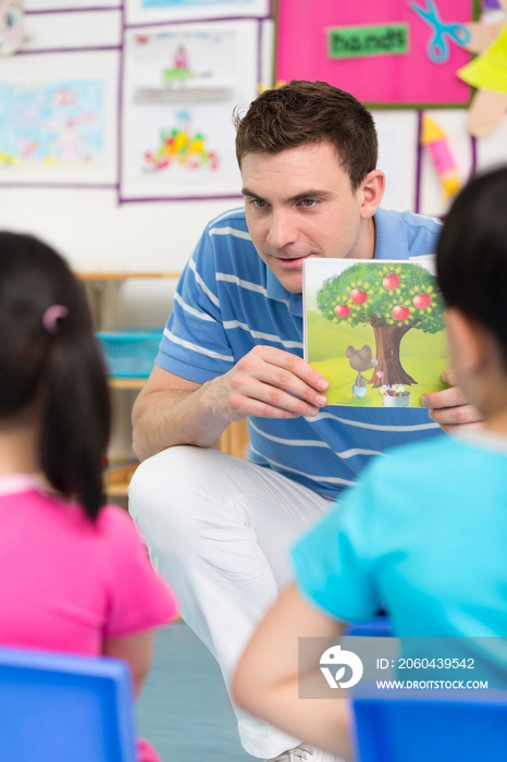 幼儿园外教男老师和儿童一起看画册
