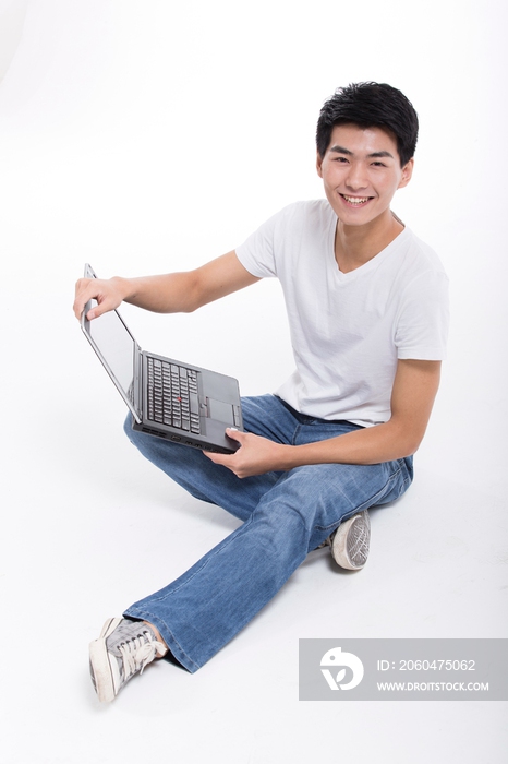 棚拍休闲装年轻男人盘腿坐使用笔记本电脑