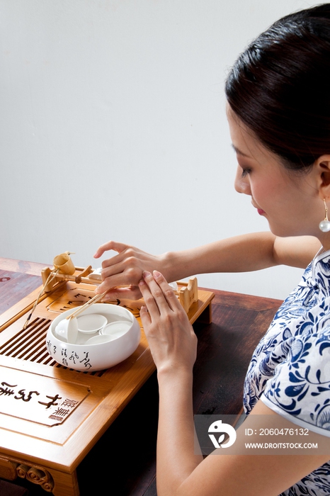 棚拍身穿中国传统服装的年轻女人秀茶艺