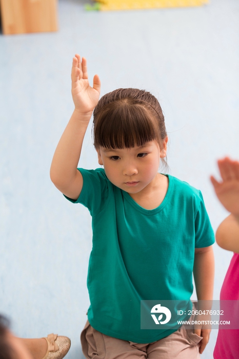 幼儿园儿童举起手回答提问