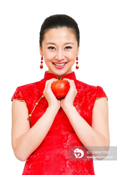 棚拍穿红色旗袍的年轻女人拿着苹果