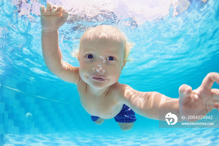 Funny face portrait of little baby boy swimming and diving underwater with fun in  pool. Active heal