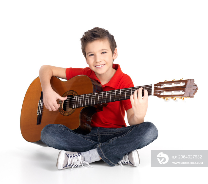 happy  boy is playing on acoustic guitar