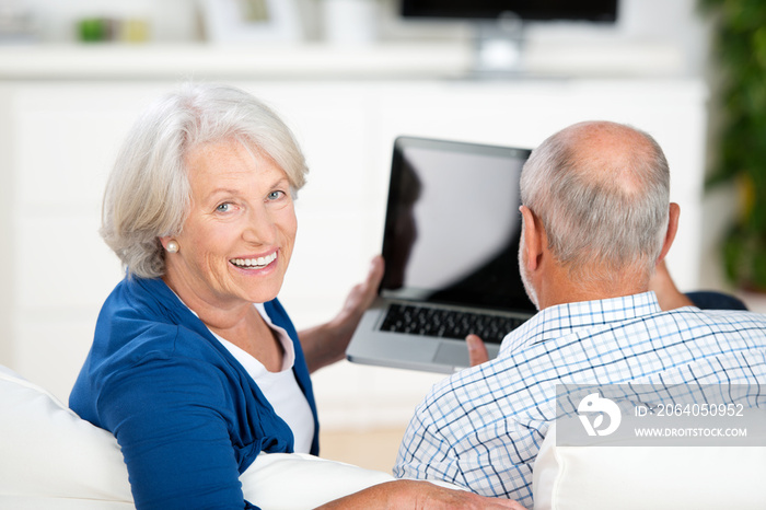 幸福的老年夫妇手里拿着笔记本电脑