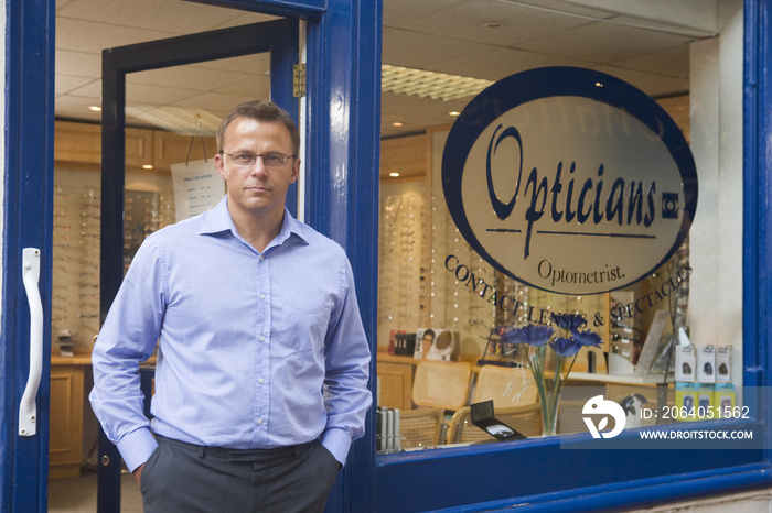 Man standing at front entrance of optometrists