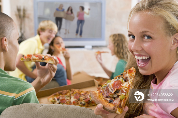 青少年在电视前吃披萨
