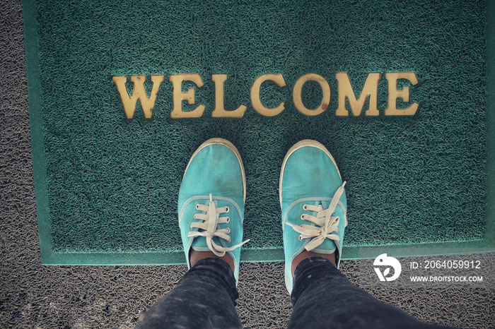 Selfie of sneakers with welcome doormat