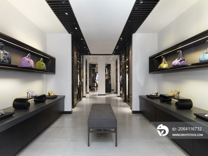 Interior of clothes store with shoes and purses on display