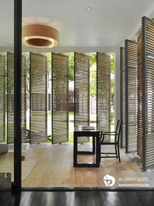 Chair and table with louvered shutters at The Library; Hat Chaweng