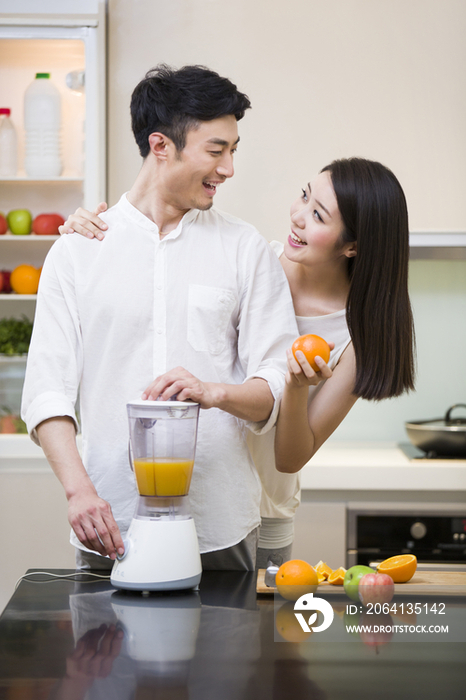 年轻夫妇在厨房使用榨汁机