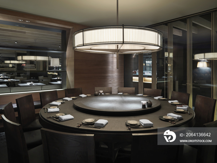 Circular dining table below light fixture in restaurant