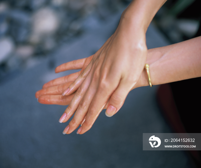 Woman applying essential oil on her hands