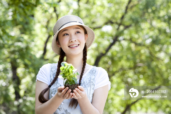 青年女子手捧植物