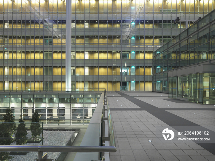 Trees in courtyard with elevated walkway in modern office building