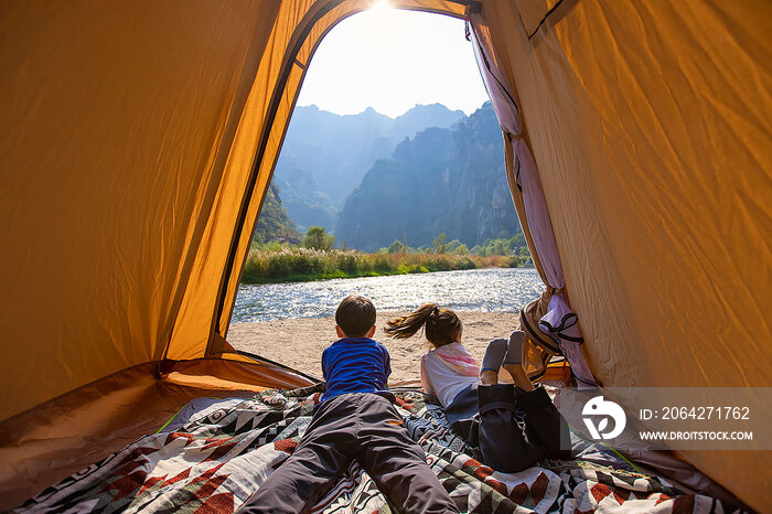 可爱的兄妹俩在帐篷里欣赏周围的自然美景