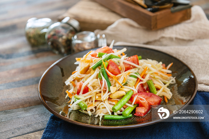 Traditional Thai food papaya salad prepared with fine slices of papaya, tomatoes, green beans and pe