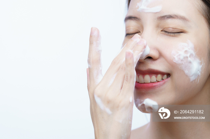 Asian woman wash her face with bubble cleansing foam isolated on white background.