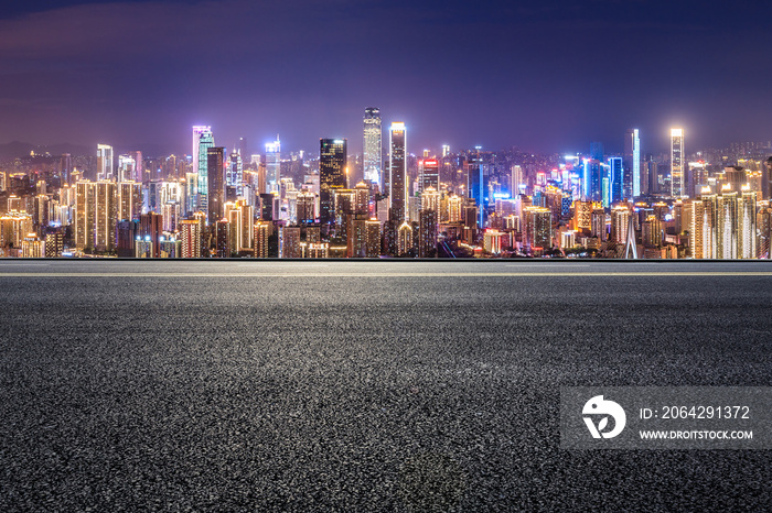 全景天际线和空荡荡的现代商业建筑。夜晚的沥青道路和城市景观