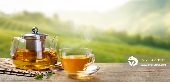 早上用茶壶泡一杯温热的茶，绿色的茶叶放在长时间种植园的木桌上