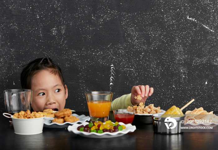 Cute Asian little girl eating happily