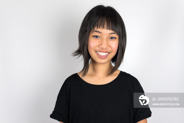 Young beautiful asian teenage girl isolated against white background.