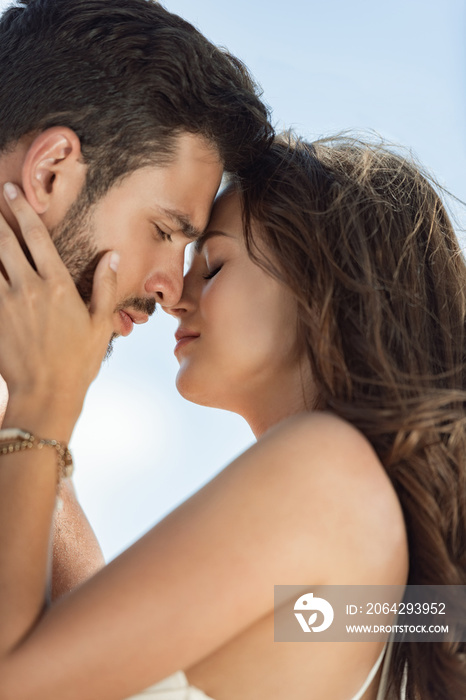 portrait of beautiful happy couple hugging and going to kiss