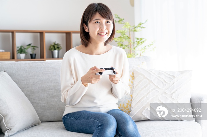 家でゲームをするアジア人女性