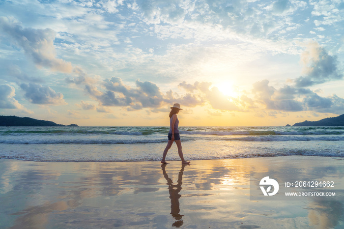 Happy Asian woman relaxing and enjoying at the beach during travel holidays vacation outdoors at oce