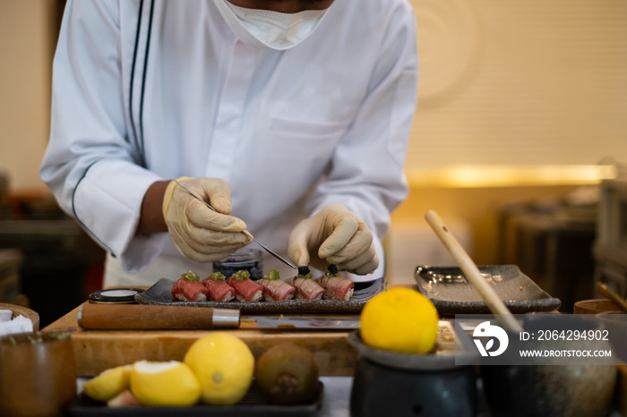 厨师手准备日本食物的特写。日本厨师在餐厅制作寿司。年轻厨师