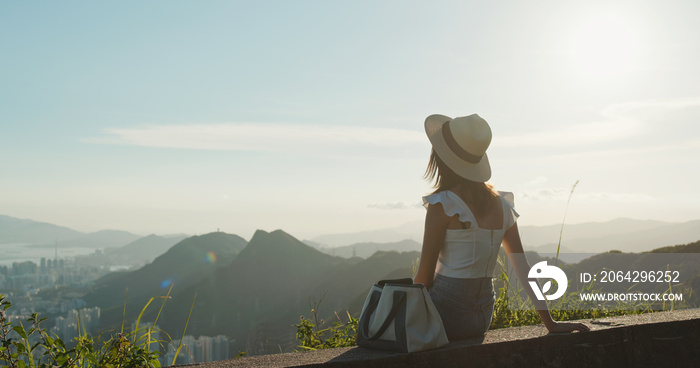 日落时分，女人在山上欣赏风景