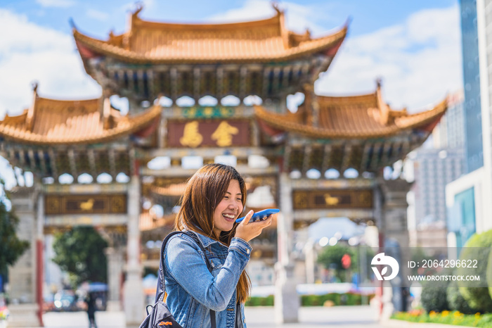 亚洲旅行女性在旅行时使用智能手机作为语音命令记录器进行翻译