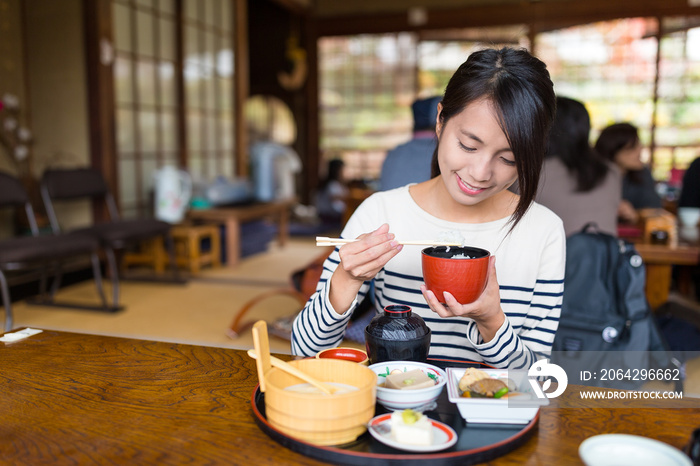 Woman eating in Japanese restaurant