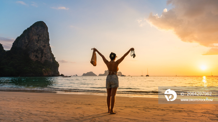 Traveler woman on summer vacation joy fun nature view scenic landscape at sunset Railay beach Krabi,