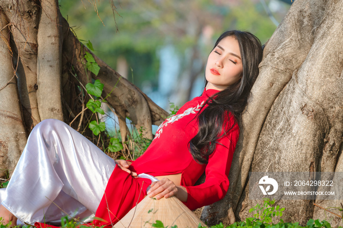 越南女孩的肖像传统红色连衣裙，美丽的年轻亚洲女人穿着越南