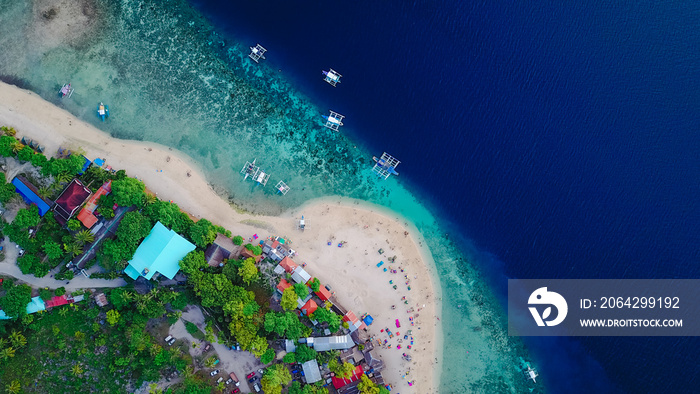 Aerial view of sandy beach with tourists swimming in beautiful clear sea water of the Sumilon island