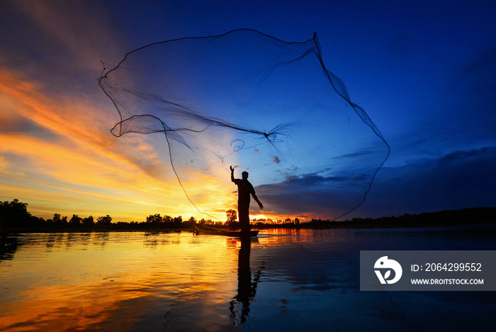 The silluate fisherman trowing the nets  on boat in river  at during sunset,Thailand fisherman,fishe