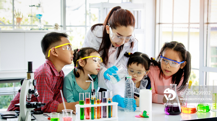 Asian female professional scientist teacher in white lab coat rubber gloves and safety glasses pouri