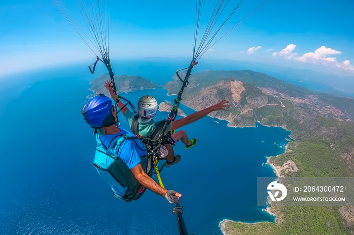 Ölüdeniz    Paragliding in the sky. Paraglider tandem flying over the sea with blue water and mounta