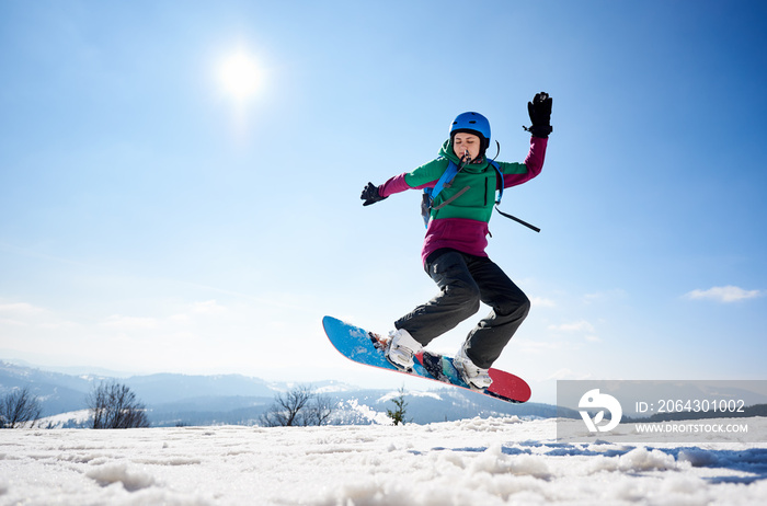 运动型年轻女子单板滑雪运动员在透明双桅帆船的复制空间背景下进行危险的空中跳跃