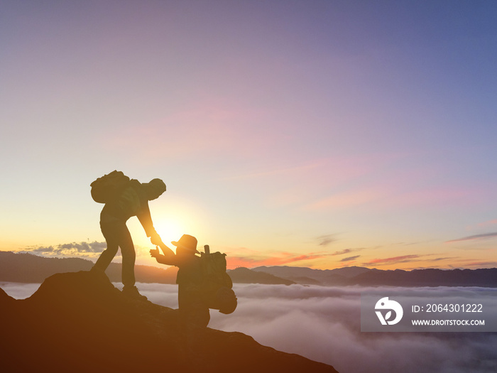 两个人登山、帮助、帮助、徒步旅行和团队合作的剪影