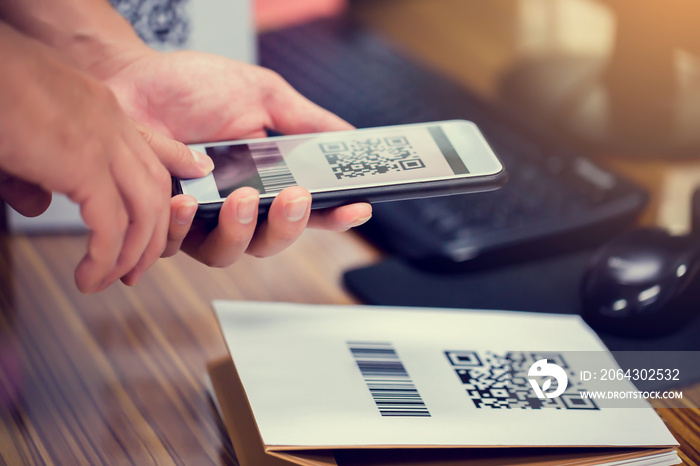 Closeup of a hand holding phone and scanning qr code. Man hand paying with qr code. Customer hand ma