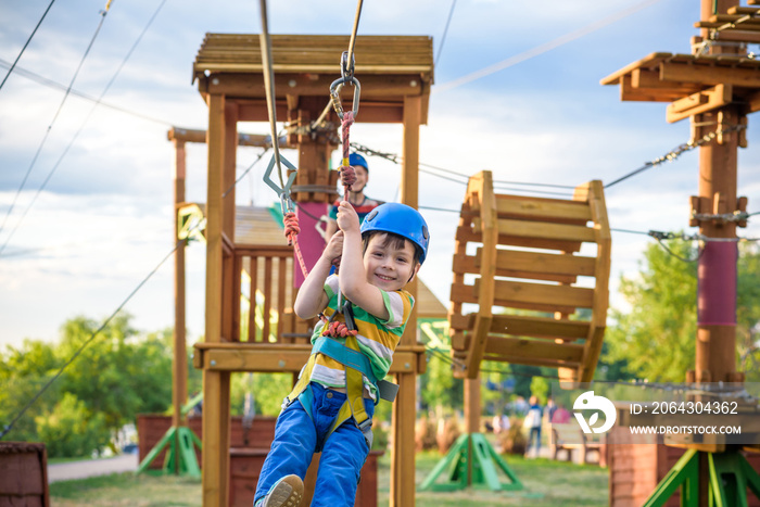 Little cute boy enjoying activity in a climbing adventure park on a summer sunny day. toddler climbi