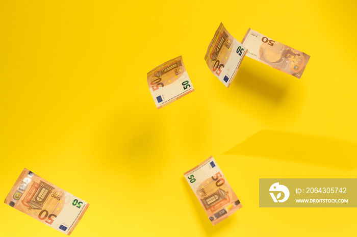 欧元钞票如雨，黄色背景下飘落的钞票，面对fi的欧洲货币