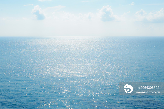 Clear blue sky and sea surface sparkling.