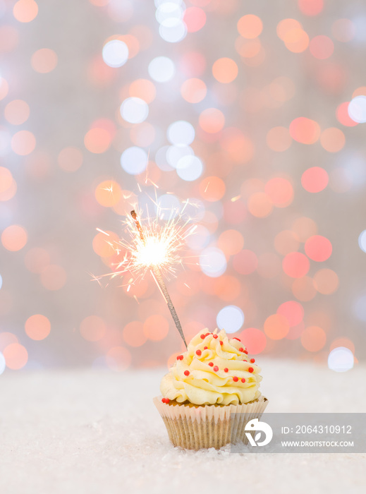 Cupcake with sparkler and fairy lights. Empty space for text